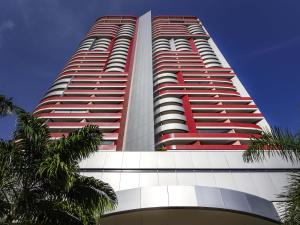 a tall red and white building with palm trees at Mercure Salvador Boulevard Hotel in Salvador