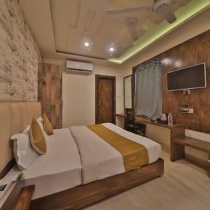 a bedroom with a bed and a tv on a wall at Hotel Jhanki Residency Near Kashi Temple in Varanasi