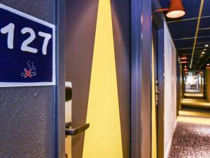 Znak na ścianie obok korytarza w obiekcie ibis budget Coutances w mieście Coutances