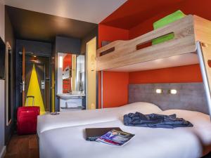 sypialnia z 2 łóżkami i pomarańczową ścianą w obiekcie ibis budget Coutances w mieście Coutances +45 zdjęć