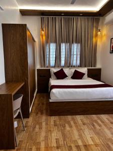 a bedroom with a large bed and a window at The lawrences aqua stay in Cochin +9 photos