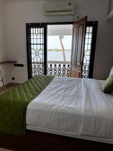 a large bed in a room with a window at The lawrences aqua stay in Cochin