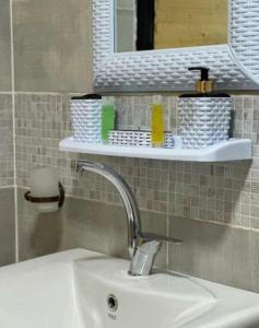 a bathroom sink with a mirror and a shelf above it at Wadi rum wanderlust camp in Wadi Rum