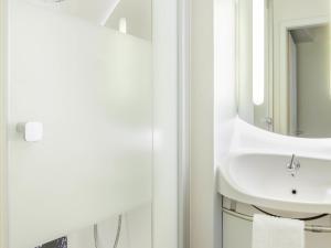a bathroom with a sink and a mirror at Ibis Budget Mulhouse Centre Gare in Mulhouse +39 photos