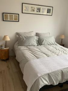 - un lit blanc dans une chambre avec deux lampes dans l'établissement maison de charme avec jardin,pacé,proche de Rennes, à Pacé