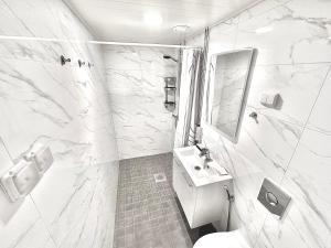 a white bathroom with a sink and a toilet at Katariina Apartments in Kotka