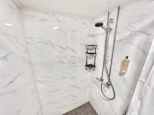 a bathroom with a shower with white marble walls at Katariina Apartments in Kotka