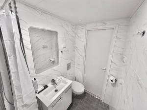 a white bathroom with a sink and a toilet at Katariina Apartments in Kotka +203 photos