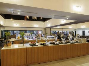 a restaurant with a counter with dishes on it at Mercure Kakadu Crocodile in Jabiru