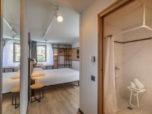 a bedroom with a bed and a walk in shower at ibis Ciboure Saint-Jean-de-Luz in Ciboure