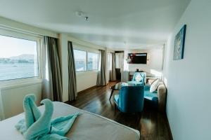 a room with a bed and a couch and a window at Nile Cruise 3 & 4 & 7 Nights in Luxor