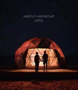 two people standing in front of a tent at night at Wadi rum wanderlust camp in Wadi Rum