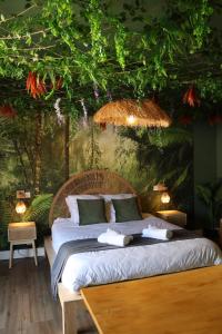 a bedroom with a bed and a wall with plants at Suite Mahé in Port-de-Bouc