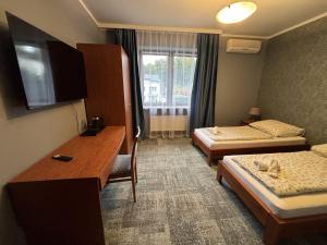 Una habitación de hotel con dos camas y un escritorio. en Gościniec Witomino, en Gdynia