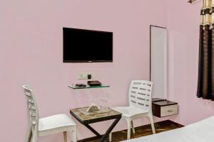 a room with a table and two chairs and a tv at Townhouse Soni Inn in Rāipur +43 photos