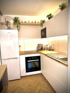 a white kitchen with a refrigerator and a dishwasher at Le QG des Super Héros Marvel in Nevers