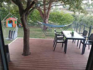 a patio with a table and chairs and a hammock at Refúgio Da Pinheira in Marco de Canaveses