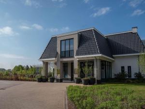 een wit huis met een zwart dak bij Hotel Ter Zand - Handwritten Collection in Burgh Haamstede