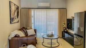 ein Wohnzimmer mit einer Couch und einem Glastisch in der Unterkunft Willow Villa Apartments, at The Fig in Gaborone
