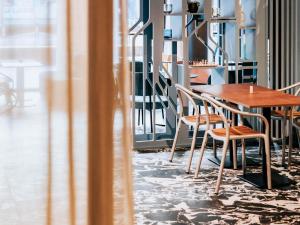 Una mesa y sillas de madera en una habitación con ventana. en Mercure Brest Centre Port, en Brest