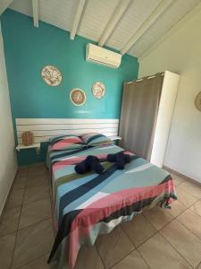 a bedroom with a bed with blue walls at Coco-orchidées Le Domaine Mannou in Sainte-Rose