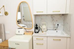 a white kitchen with a sink and a mirror at Apartment am Michel mit Parkplatz in Hamburg