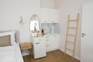 a white kitchen with a bed and a mirror at Apartment am Michel mit Parkplatz in Hamburg