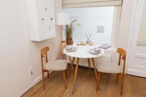 a white table and chairs in a room with a window at Apartment am Michel mit Parkplatz in Hamburg +6 photos