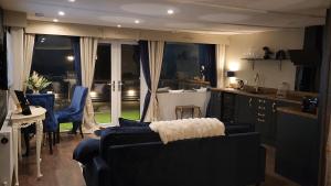 ein Wohnzimmer mit 2 Sofas und einer Küche in der Unterkunft Mary Queen of Scott's Lodge in Carberry