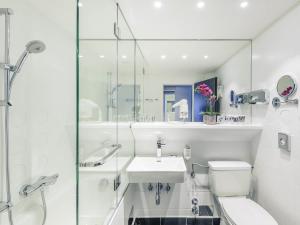 a bathroom with a sink and a toilet and a shower at Mercure Hotel Raphael Wien in Vienna