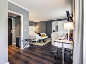 a hotel room with a bed and a desk and a bedroom at Mercure Hotel Raphael Wien in Vienna