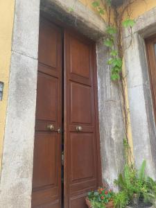 eine Holztür an der Seite eines Gebäudes in der Unterkunft AL Castello in Melfi