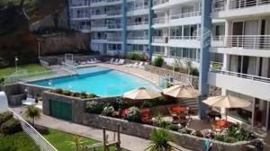 バルパライソにあるConcon vista al mar en Costa Lilenes hasta 6 personasのアパートメントの建物の前にスイミングプールがあります。