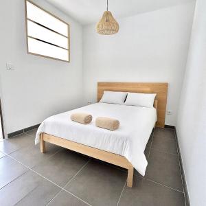 Un dormitorio con una cama con dos almohadas encima. en Maison Dolce Vita, en Ghisonaccia 7 fotos más