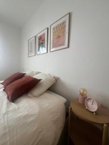 a bedroom with a bed and three pictures on the wall at T2 cosy au calme , proche Dax in Tercis-les-Bains