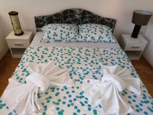 - un lit avec des serviettes et des oreillers dans l'établissement Lasofti Vrnjacka Banja, à Vrnjačka Banja