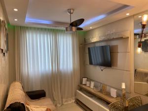 a living room with a tv on a wall at Apartamento Proximo ao Salvador Shopping in Salvador