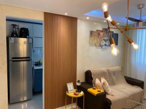 a kitchen with a refrigerator and a chair in a room at Apartamento Proximo ao Salvador Shopping in Salvador