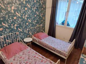 two beds in a room with a window and a wall at gite isolée proche futuroscope Airvault in Saint-Clair