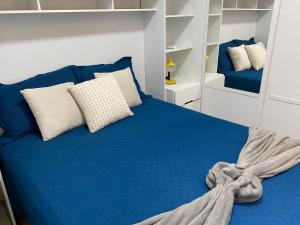a blue bed with pillows on it in a room at Apartamento Proximo ao Salvador Shopping in Salvador