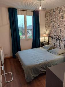 a bedroom with a bed with blue curtains and a window at gite isolée proche futuroscope Airvault in Saint-Clair