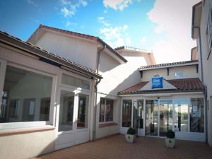 a building with a handicapped sign in front of it at Ibis Budget Agen in Le Passage