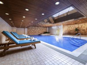 a large swimming pool with a blue recliner in a building at Novotel Beijing Peace in Beijing