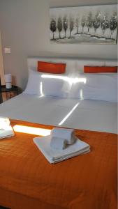 a white bed with a tray of towels on it at La Mansarda sotto il Castello in Magliano Alfieri +5 photos