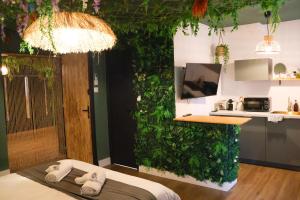 a room with a green wall with towels on a bed at Suite Mahé in Port-de-Bouc