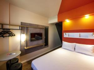 a small room with a bed and a table at ibis budget Recife Jaboatão in Recife
