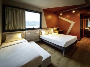 Ένα ή περισσότερα κρεβάτια σε δωμάτιο στο Ibis Budget Balneario Camboriu