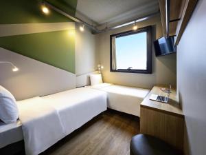 Ένα ή περισσότερα κρεβάτια σε δωμάτιο στο Ibis Budget Balneario Camboriu