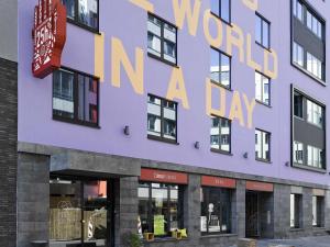 a purple building with a sign that reads world in a day at 25hours Hotel The Trip in Frankfurt/Main