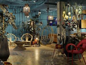 a room with chairs and plants and potted plants at 25hours Hotel The Trip in Frankfurt/Main